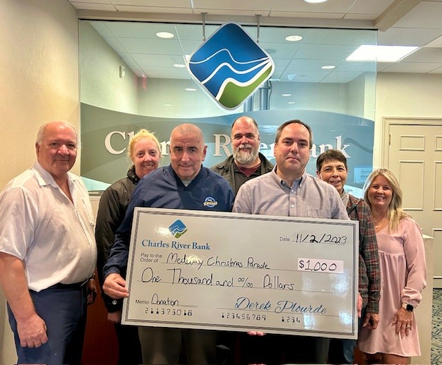 Bank team holding a big check donation.